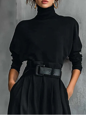 Conjunto negro de dos piezas: top cuello alto manga larga y pantalón recto con cinturón.