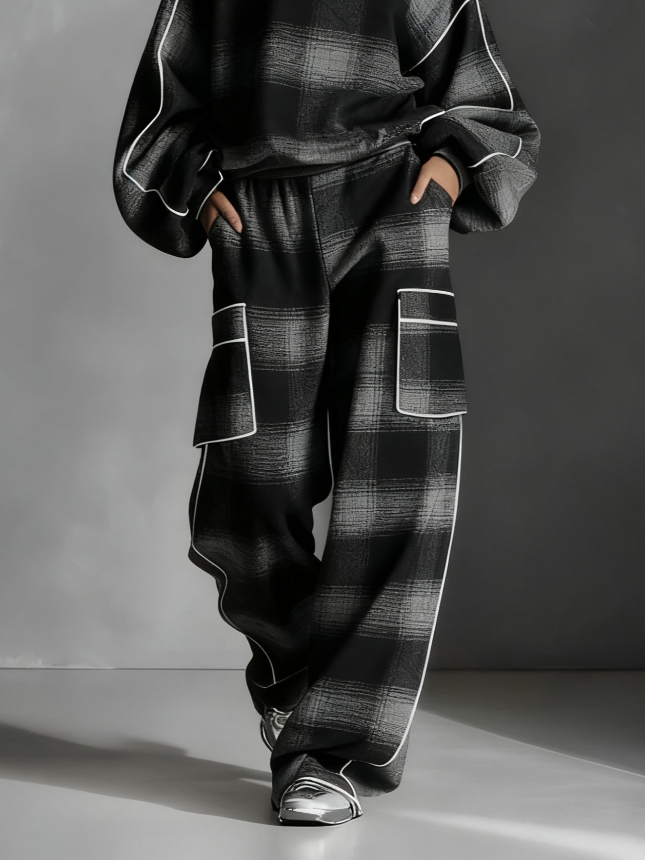 Conjunto de dos piezas con sudadera a cuadros negro/gris y pantalón casual.